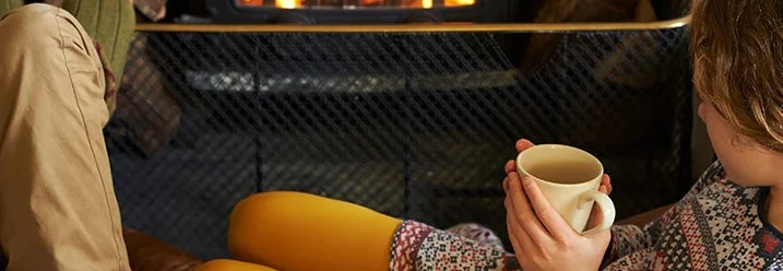 Zwei Personen sitzen vor einem Kaminfeuer